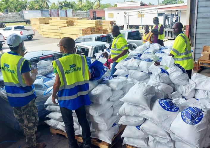 FFTP warehouse workers in Jamaica load bags of rice on trucks for hurricane preparedness week